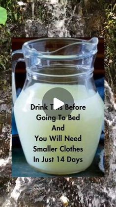 a glass jar filled with milk sitting on top of a table next to a tree