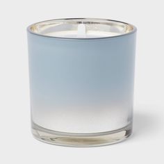 a blue glass candle holder with a single white candle in the middle and a silver rim around it