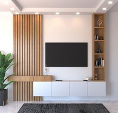 a living room with a large television on the wall next to a potted plant