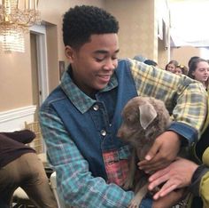 a young man holding a puppy in his lap