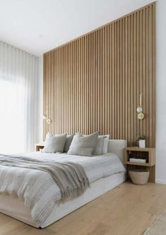 a large bed sitting in the middle of a bedroom next to a wooden headboard