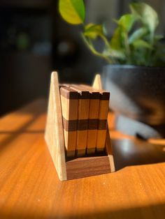 a wooden object sitting on top of a table next to a potted plant