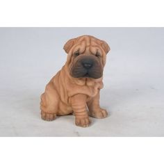 a brown dog figurine sitting on top of a white floor next to a wall