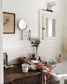 a bathroom with a sink, mirror and bathtub next to a wooden dresser in the corner