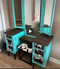 a turquoise vanity with cow hideaway stool and mirror