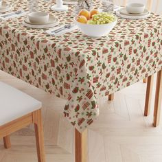 a bowl of fruit is sitting on a table with two plates and bowls of fruit