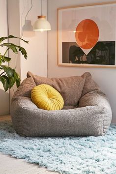 a living room filled with furniture and a potted plant on top of a blue rug