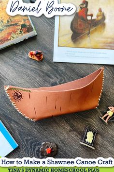 a paper boat sitting on top of a wooden table next to other crafting supplies