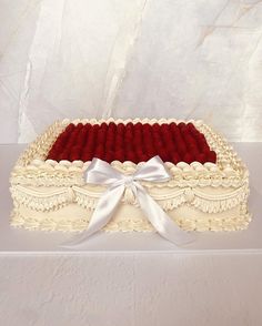 a large white cake with red velvets in the shape of a casket on a table