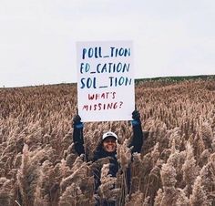 a person standing in a field holding up a sign that says pollution elevation solution what's missing?