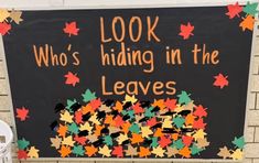 a sign that says, look who's hiding in the leaves on a wall