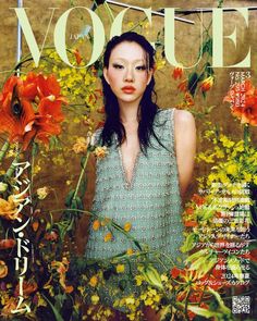 a woman standing in front of flowers on the cover of a magazine