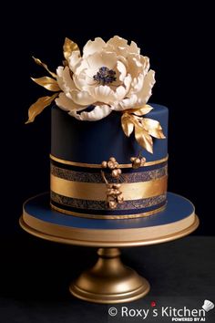 a blue and gold cake with flowers on top