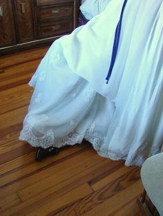 a woman in a white wedding dress laying on the floor next to a dresser and bed