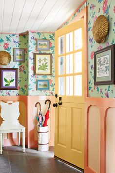 an entryway with colorful wallpaper and pictures on the walls, including umbrellas