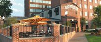 an outside view of a building with tables and umbrellas