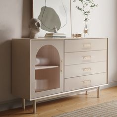 a white dresser with a mirror and vase on top