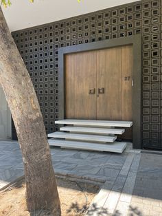 an entrance to a building with steps leading up to it and a tree in the foreground