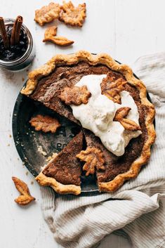 a chocolate pie with whipped cream and pretzel toppings on a black plate