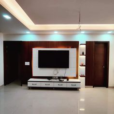 a living room with a flat screen tv on the wall and white furniture in front of it