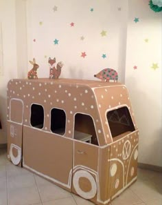 a cardboard toy bus with animals and stars on the wall