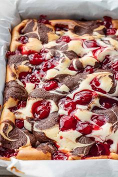 a close up of a pizza in a pan with cherries on it and cheese