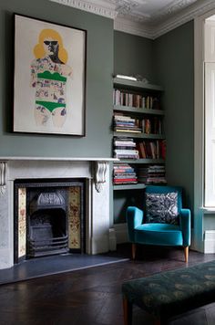 a living room filled with furniture and a fire place in front of a book shelf