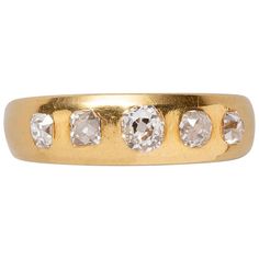 a gold ring with five diamonds on it