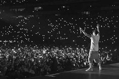 a man standing on top of a stage in front of a crowd