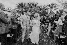 a bride and groom walk down the aisle as confetti is thrown around them