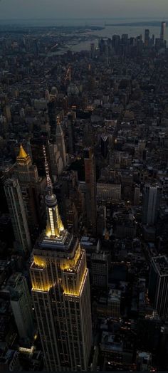 an aerial view of new york city at night with the empire building lit up in yellow