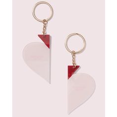 two heart shaped acrylic keychains with red and white shapes on them