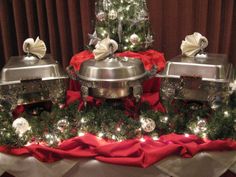 three silver dishes on a table with christmas decorations