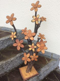 a vase filled with flowers sitting on top of a wooden table next to some stairs