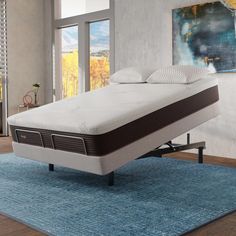 a bed with a mattress on top of it in a room next to a blue rug