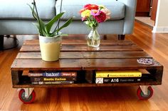 a coffee table made out of wooden pallets with flowers in a vase on top