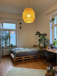 a bedroom with a bed made out of wooden pallets and plants hanging from the ceiling