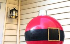 a large red and black balloon sitting on the side of a house