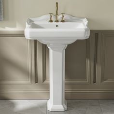 a white pedestal sink sitting next to a wall