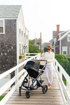 a woman pushing a stroller down a wooden walkway