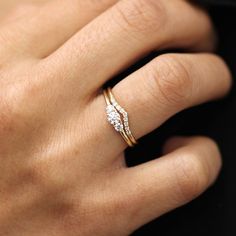 a close up of a person's hand with a diamond ring on their finger