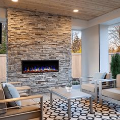 a living room filled with furniture and a fire place next to a wall mounted tv