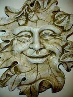 a carved face with leaves on it