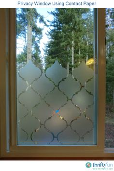 a window that has some glass on the side of it and trees in the background