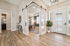 a large open living room with wood floors and white doors