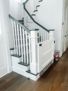 a dog is laying on the floor next to some stairs and railings in a house