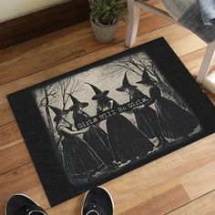 a pair of shoes sitting on top of a wooden floor next to a door mat