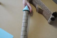 a child is making a paper castle out of toilet paper