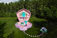 an aerial view of a barbie doll house in the middle of a field with a tent