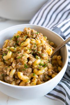 a bowl filled with macaroni and cheese on top of a white tablecloth